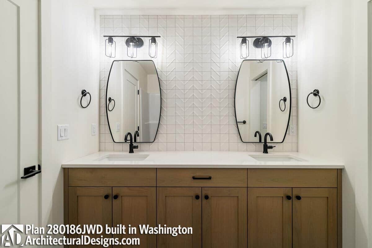 The shared bathroom offers a wooden vanity equipped with two sinks and wrought iron fixtures.