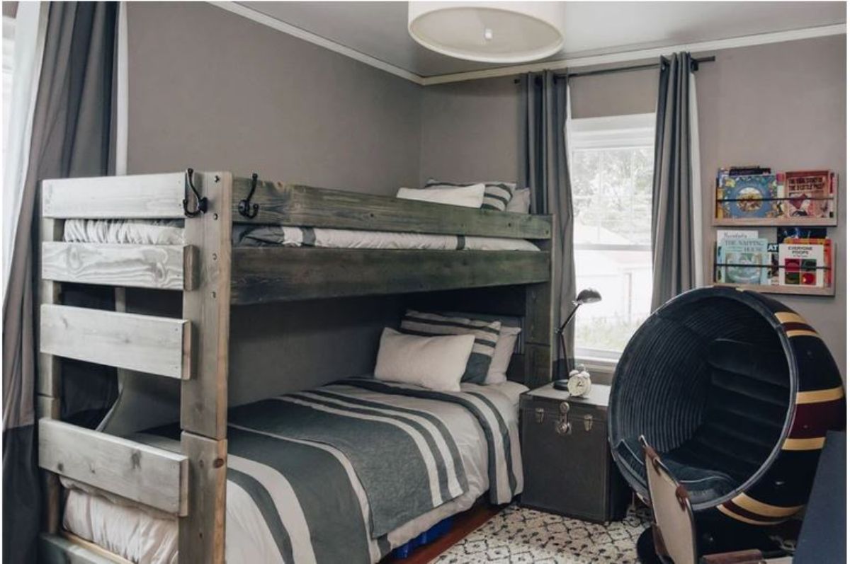 Two wooden bunk beds with sheets and pillow colored with white and gray.