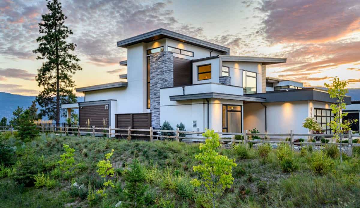 Home's faรงade embellished with stone, stucco, and wood siding.