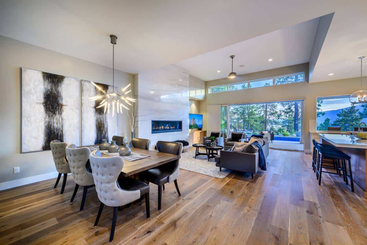 An open layout view of the dining area, kitchen, and living room enhanced by a taller ceiling.