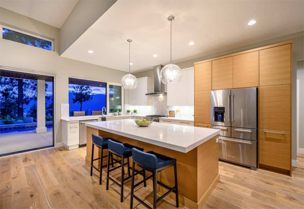 The kitchen is equipped with premium appliances, custom cabinetry, and a center island with bar seating.