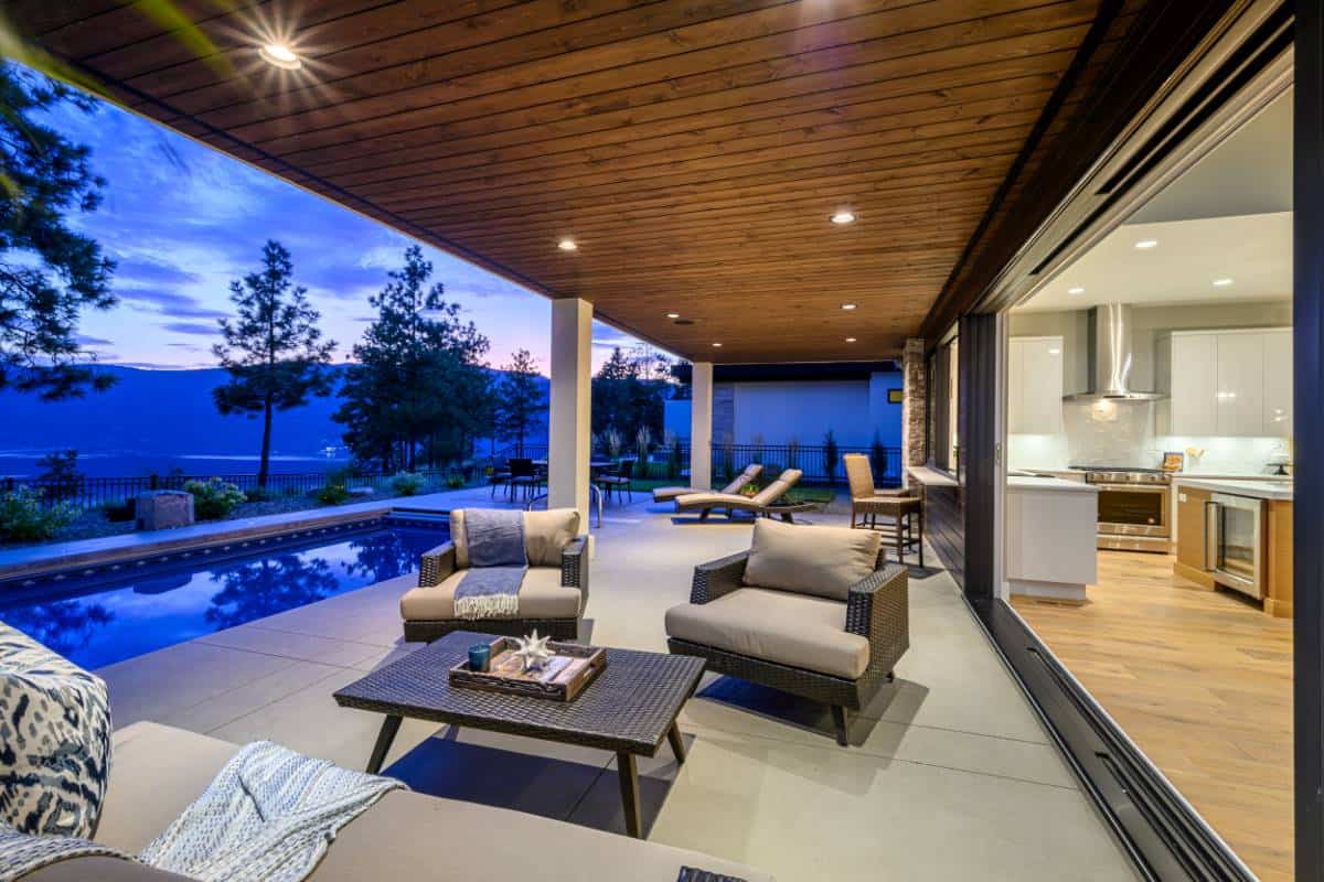 A wood paneled ceiling enhances the cozy ambiance in the covered deck.