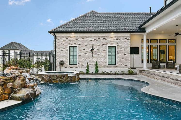 A stone waterfall feature adorns the pool terrace.