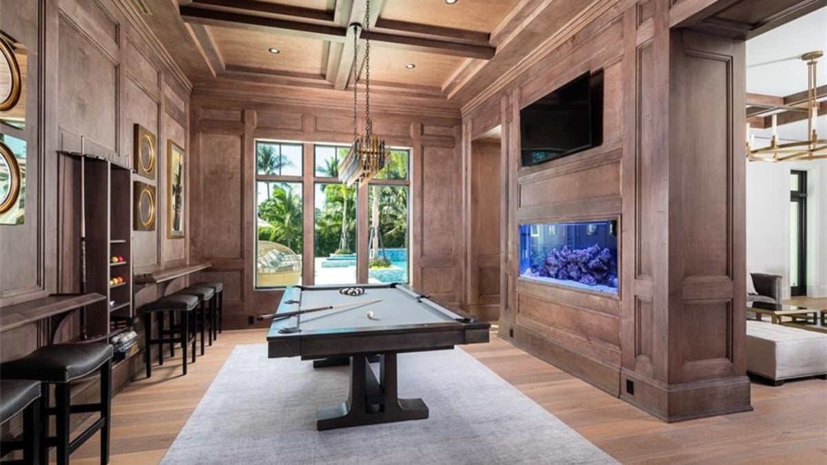 A recreational room with table pool, television and classic window pane.