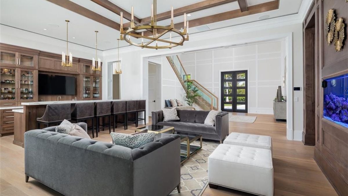 A modernized living room with sofas, aquarium and chandelier.
