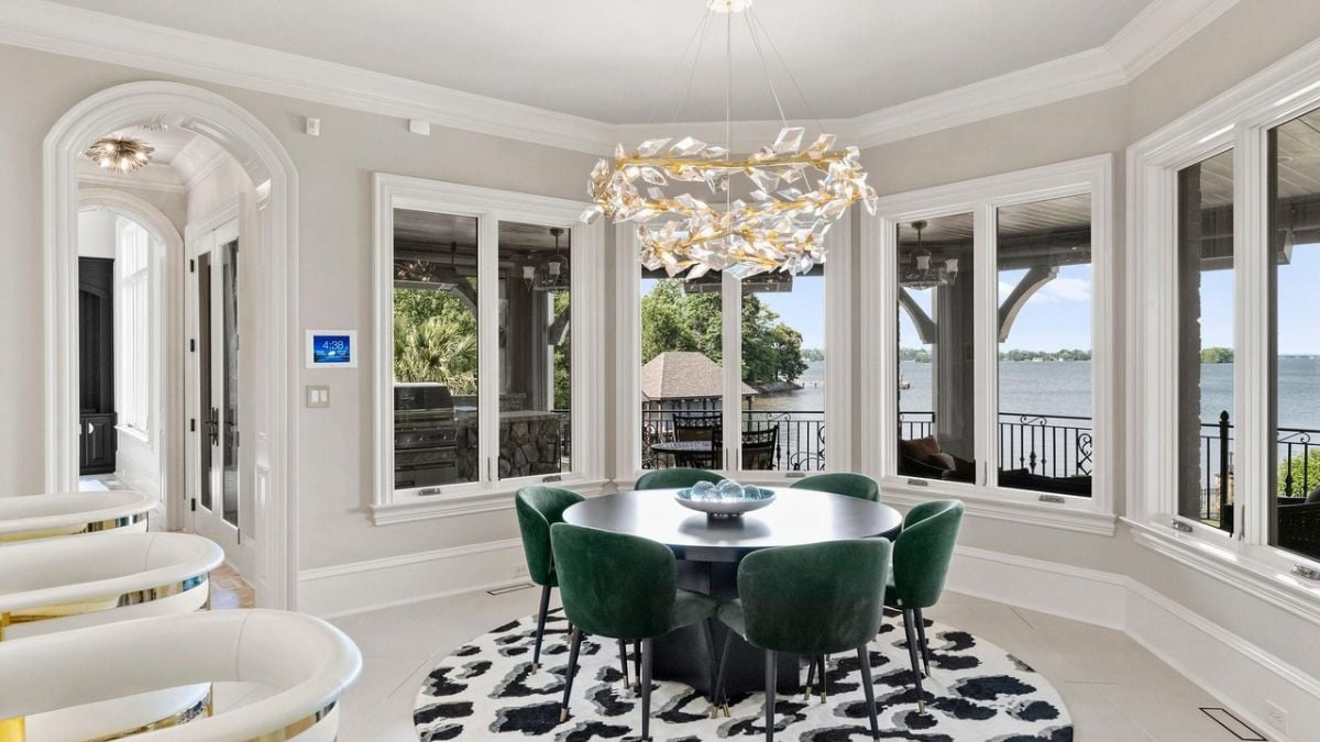 Emerald fabricated dining chairs alongside the windowpanes