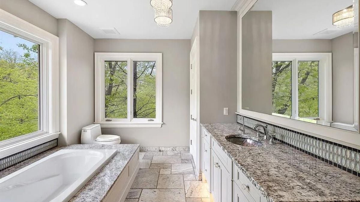 Marble designed bathroom with tub and closet