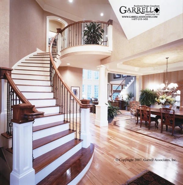 Foyer with a two-story ceiling and an elaborate curved staircase leading to the secondary bedrooms.