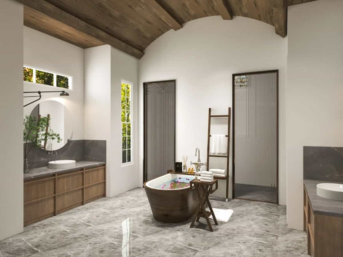 Primary bathroom with his and her sink vanities, a walk-through shower, and a freestanding tub under a barrel-vaulted ceiling.