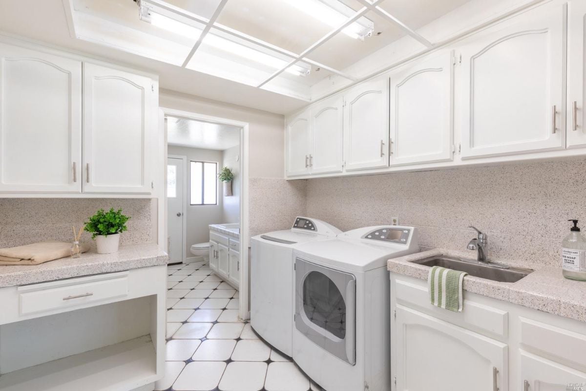 Laundry room with a washer, dryer, and sink.
