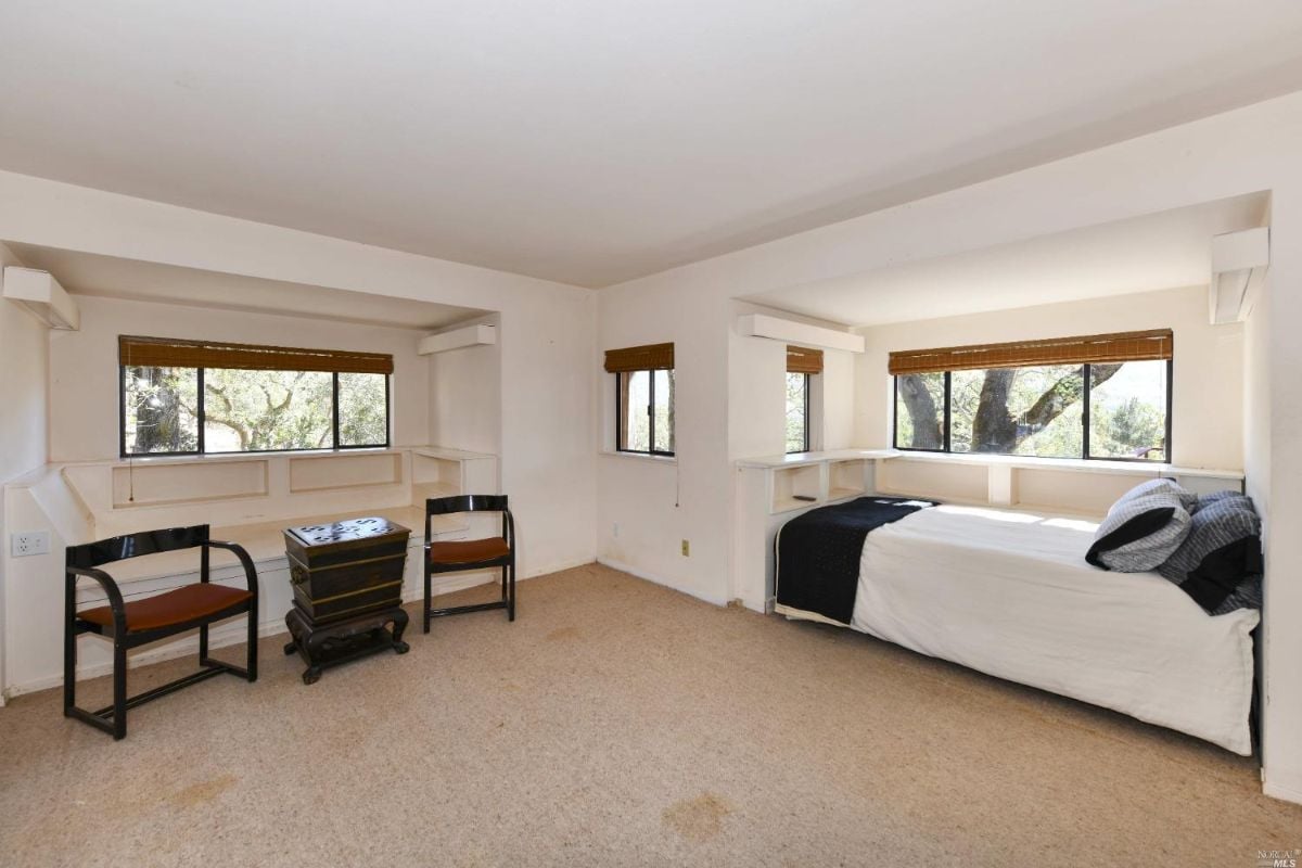 Carpeted bedroom with glass windows.