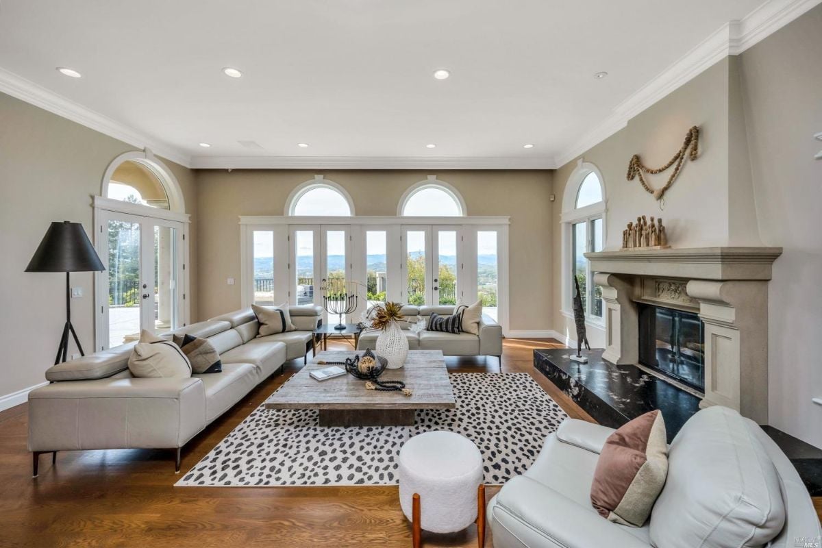 Living room with a fire place and large glass doors.