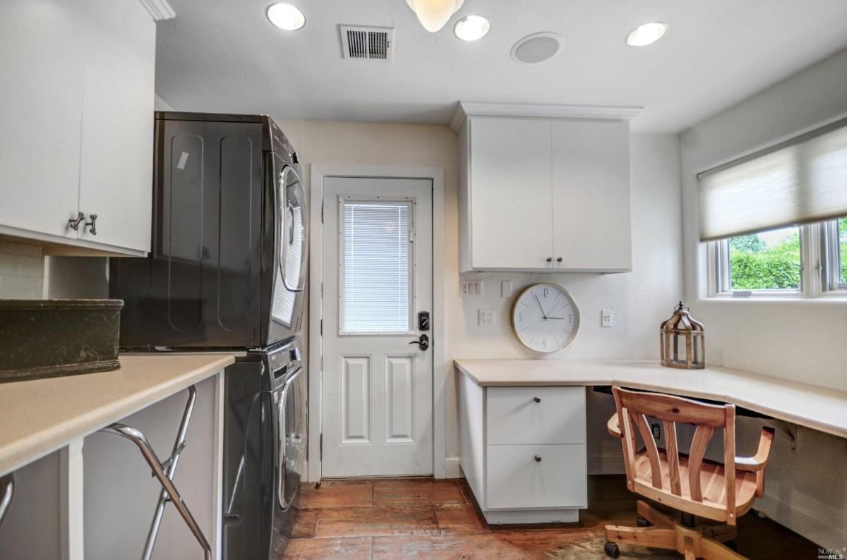 Laundry room with white cabinets.