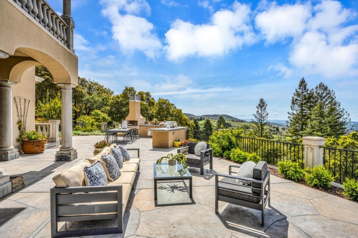 Patio with table, chairs and a view of the trees.