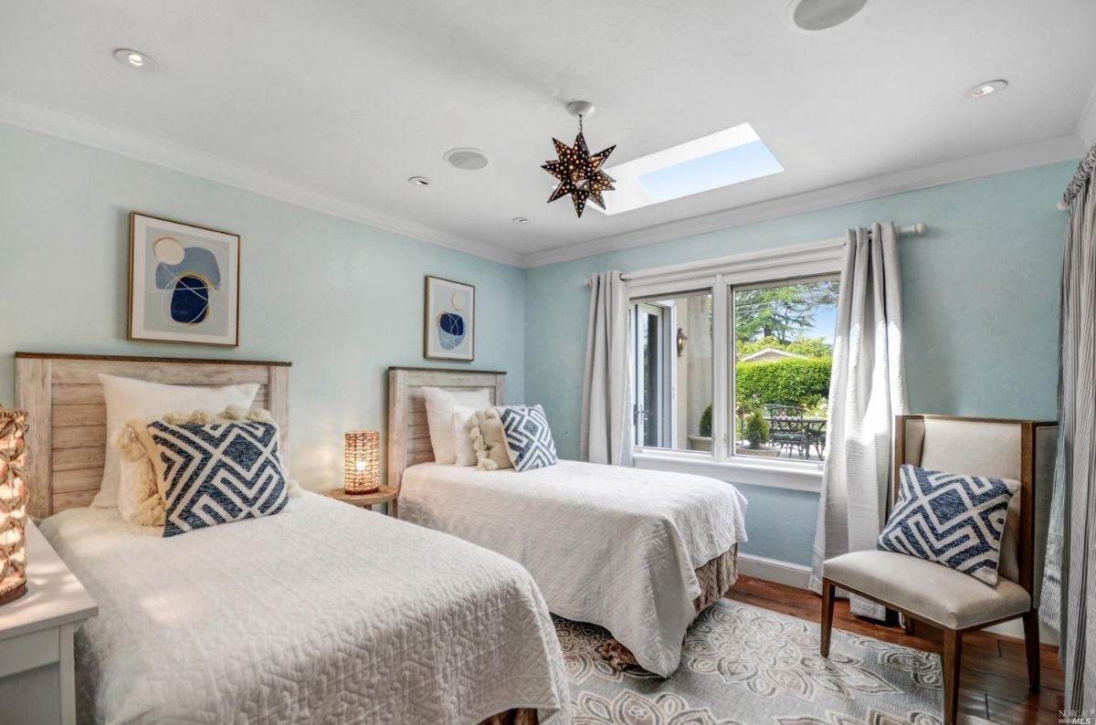 Bedroom with two beds and glass window.