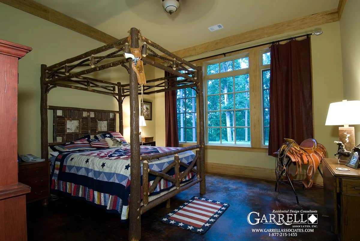 Primary bedroom with a canopy bed and a view of the lush backyard.