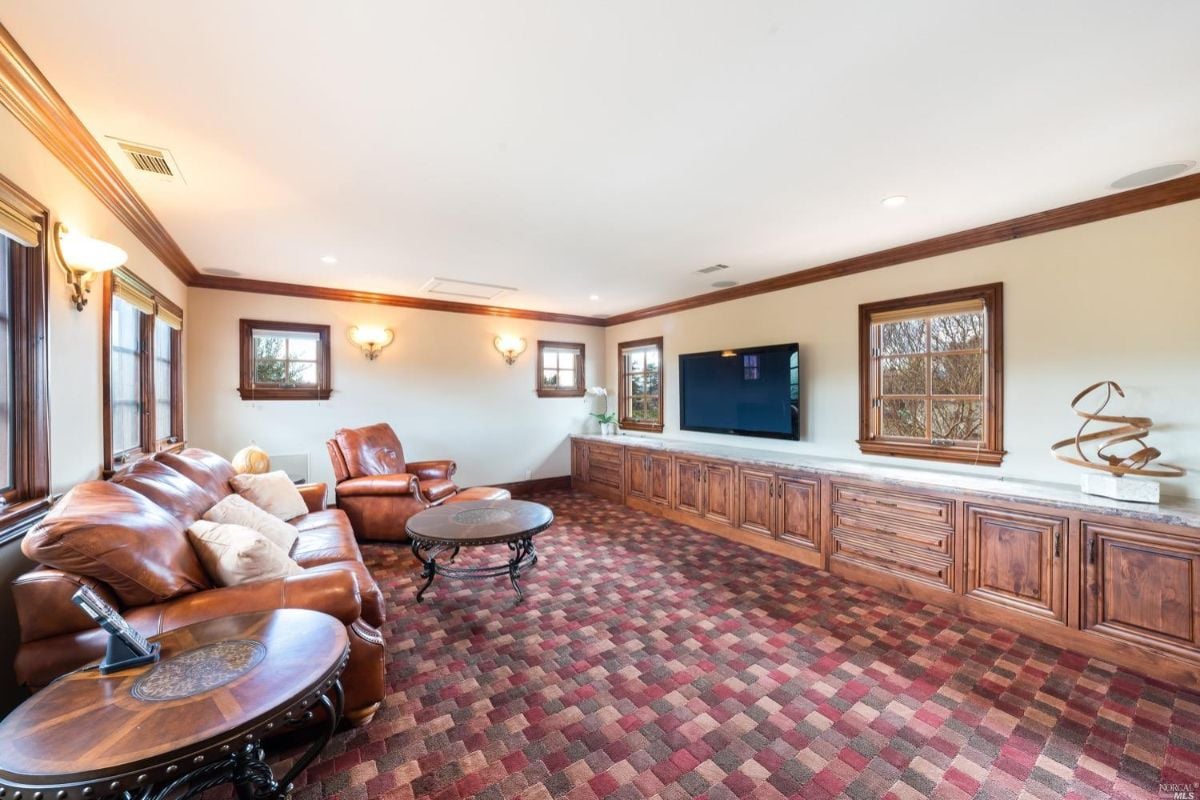 Media room with couches and huge television.