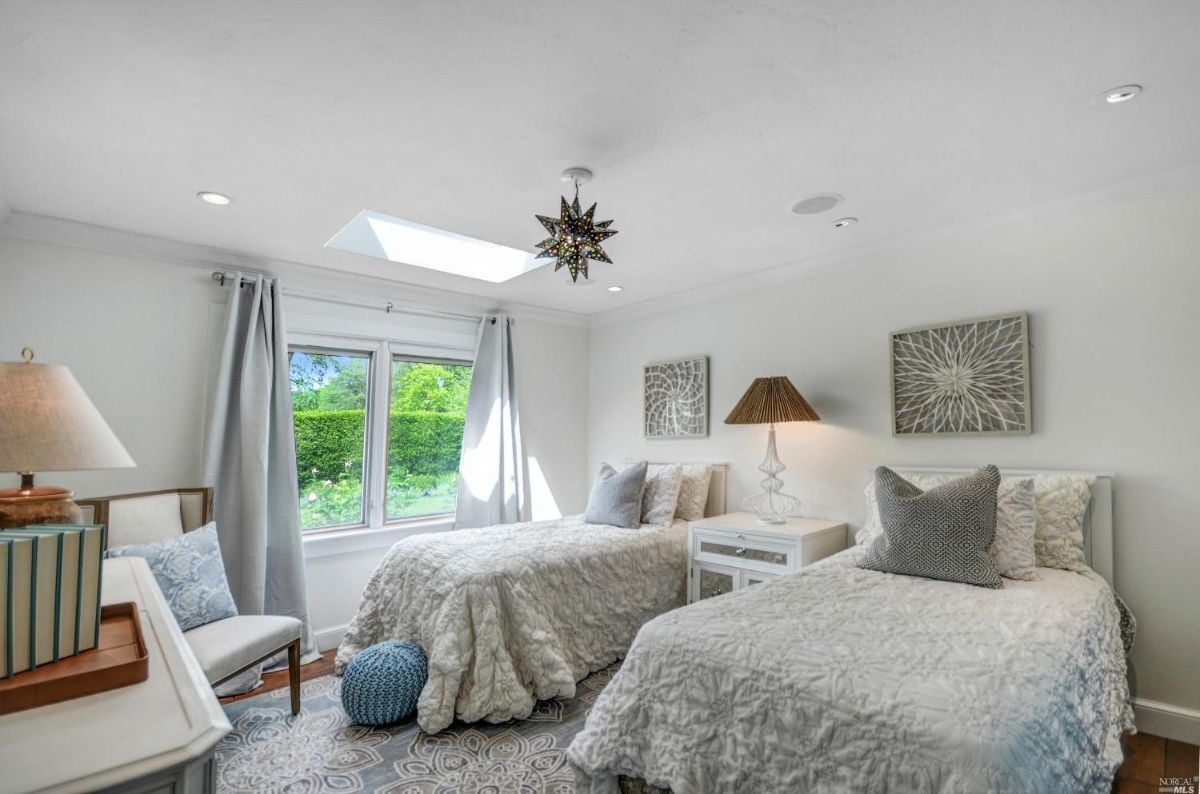 Bedroom with two beds and a ceiling fan.