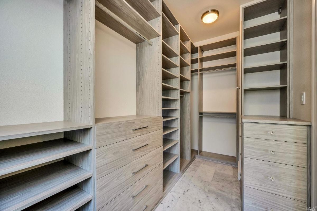 Walk-in closet with wooden shelves.