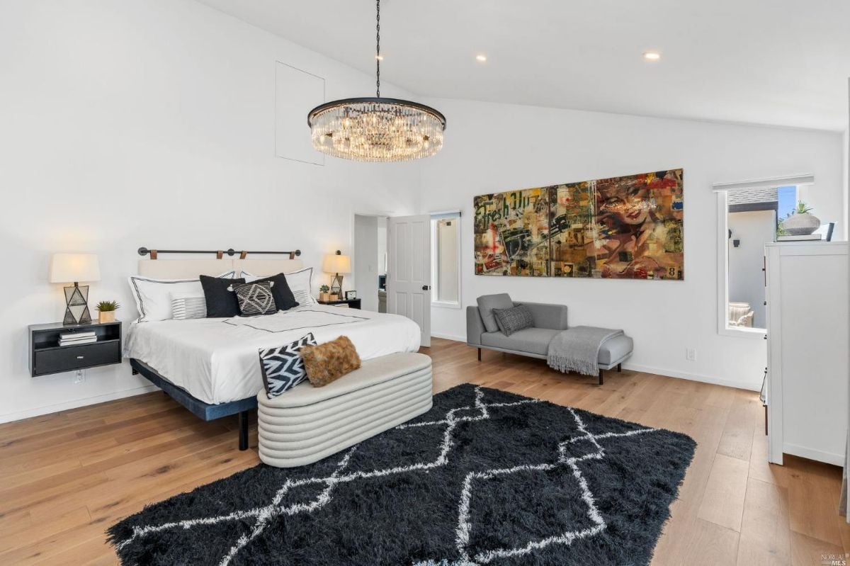 Bedroom with wood floorings and chandelier.