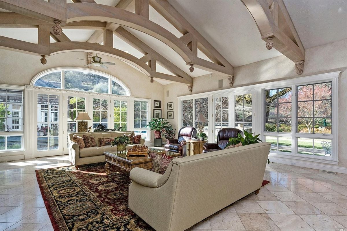 Living room with a large couch and a view of the backyard lawn.
