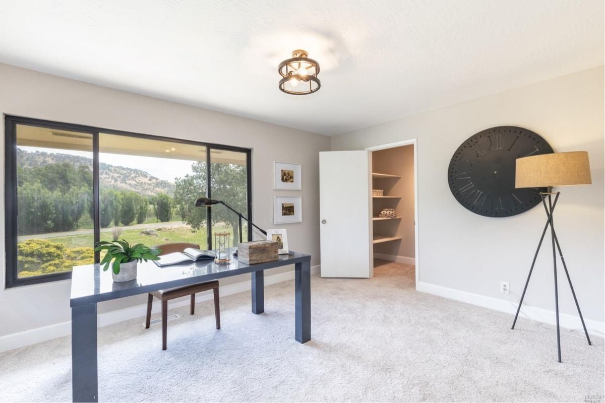 Home office with a desk and a large window.