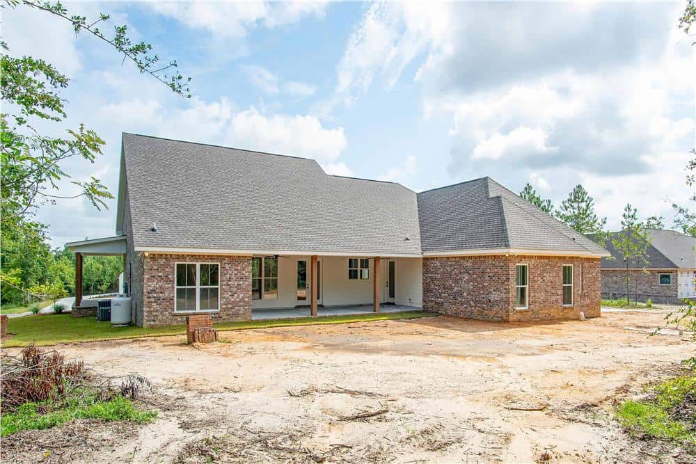 Rear exterior view with brick and stucco siding, hipped rooflines, and a covered porch lined with timber posts.