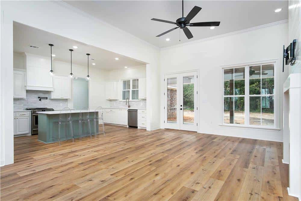 Great room and kitchen connected by an oversized opening. A French door on the back opens onto a covered porch.