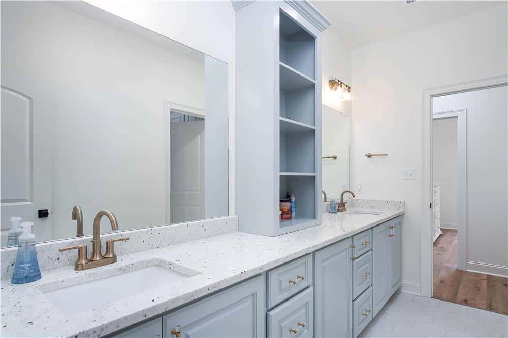 Primary bathroom with a dual sink vanity topped with frameless mirrors and built-in shelves.