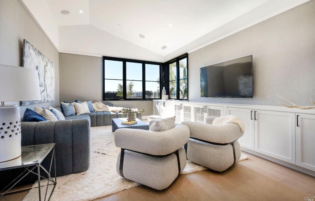 Media room with couches and a large flat screen TV.