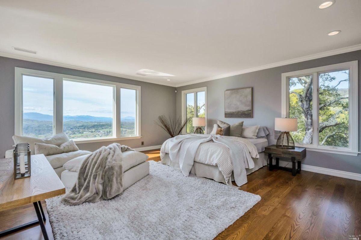 Bedroom with wooden floors and glass windows.