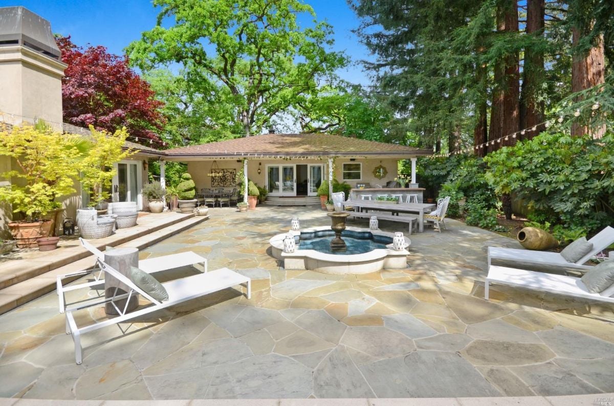 Patio with a fountain and chairs.