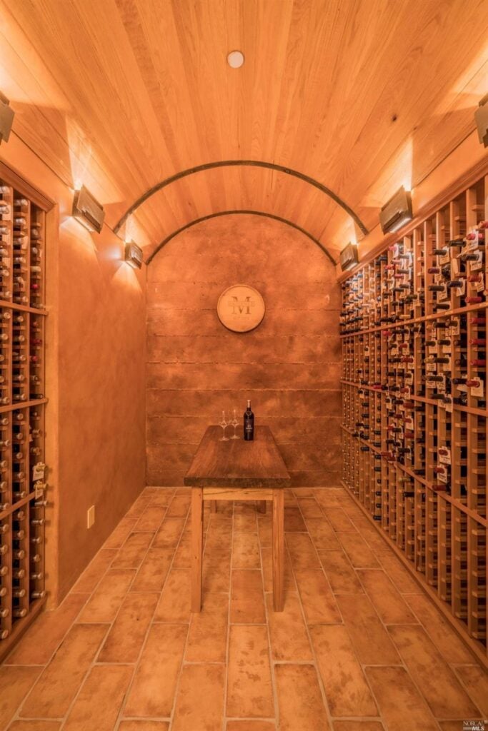 Wine cellar with a wooden ceiling and a wooden table.