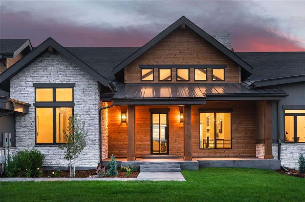 Front porch with a concrete stoop, rustic wood pillars, and a glazed entry door.
