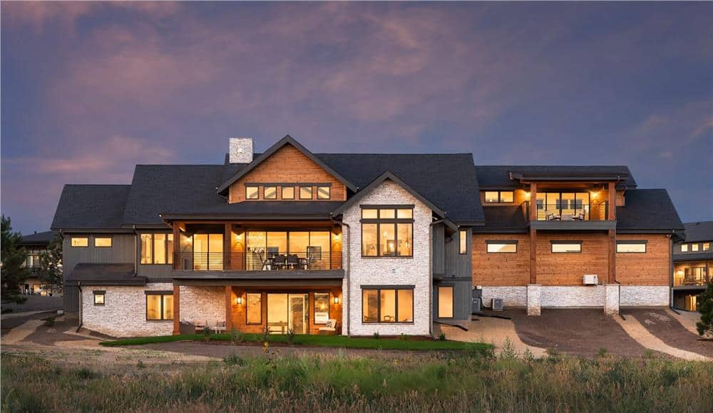 Rear view of the house showcasing its stacked porches and a multitude of windows bringing ample natural light in.