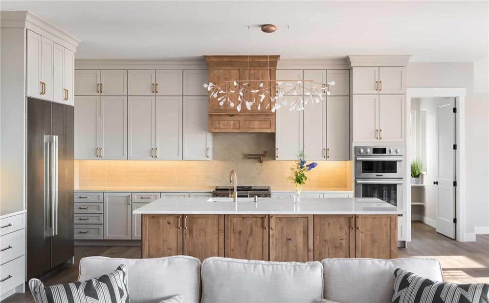 Kitchen with stainless teel appliances, white cabinetry, and a center island fitted with a prep sink.