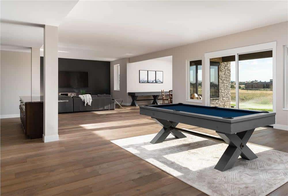 Rec room with a billiards table and oversized sliding glass doors that open onto a covered patio.