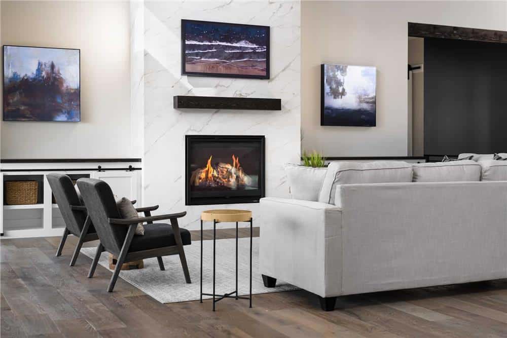 Great room with a gray sofa, leather armchairs, and a marble fireplace topped with a wall-mounted TV.