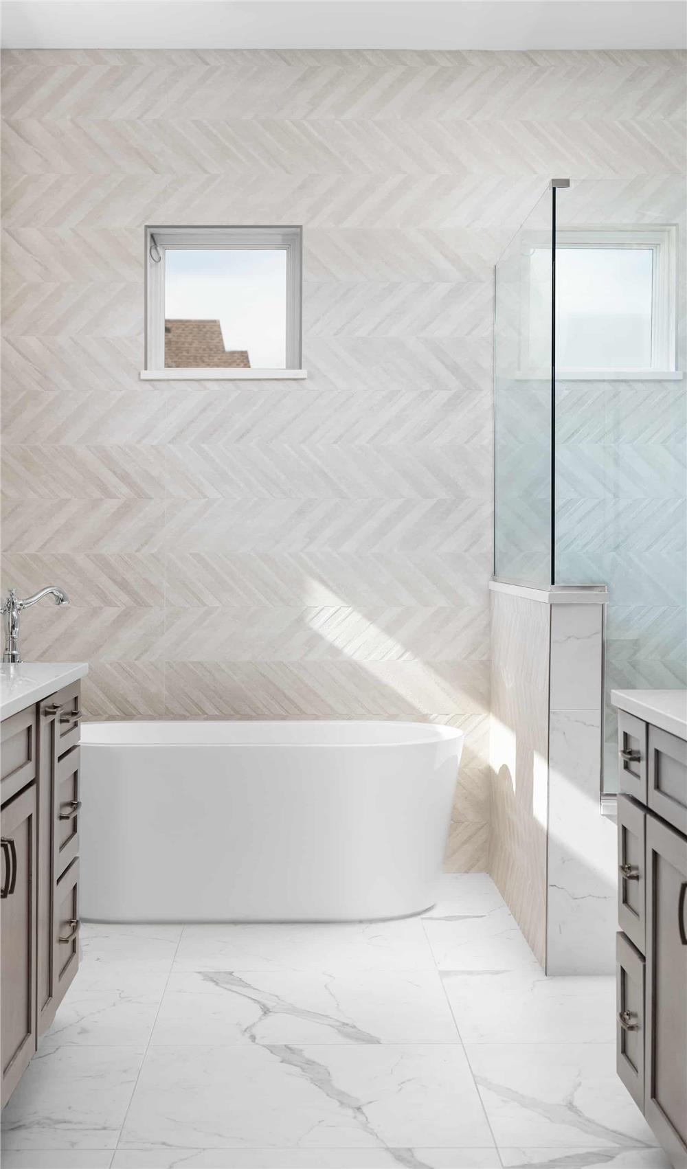 The primary bathroom includes a walk-in shower and a soaking tub over the marble-tiled flooring.