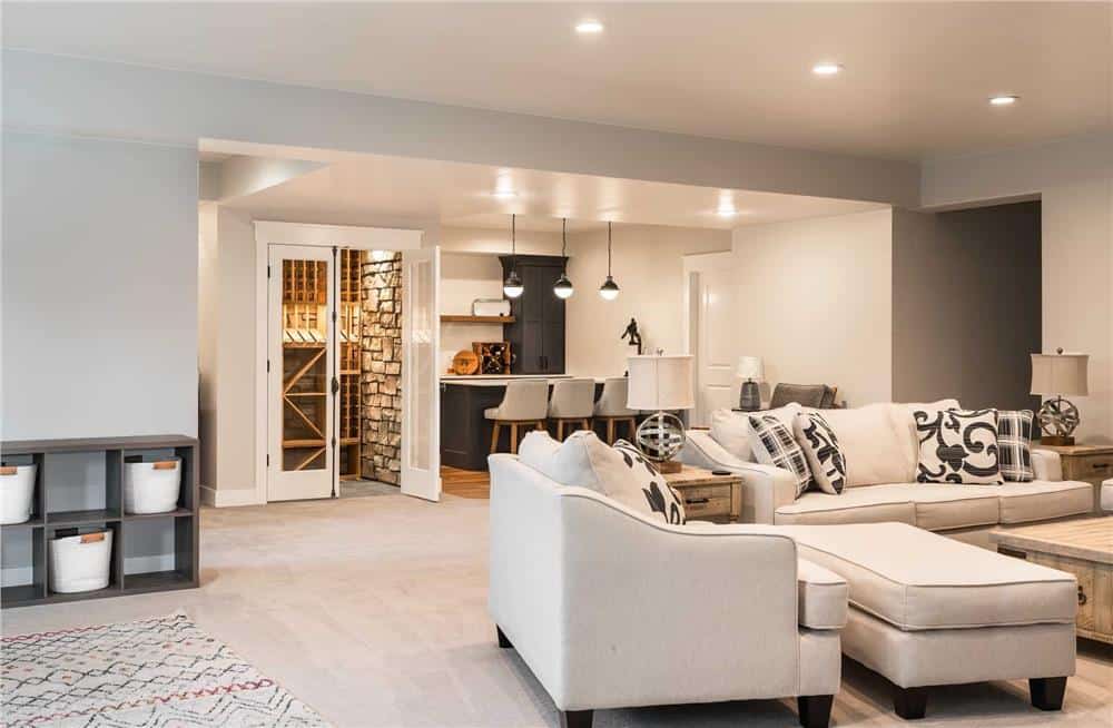 Rec room with neutral sofas, a wine cellar, and a wet bar.