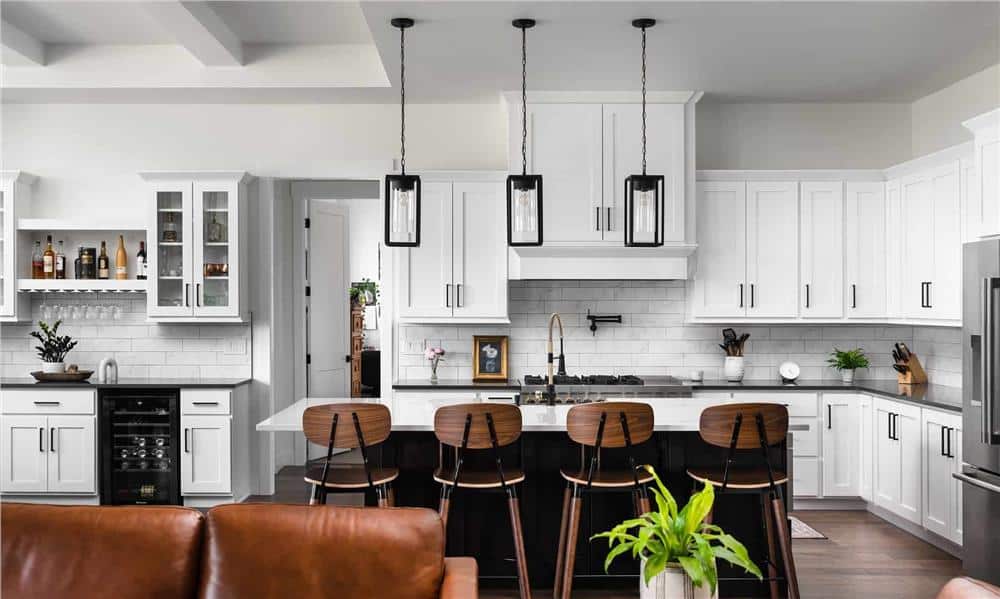 Kitchen with white cabinetry, subway tile backsplash, and a breakfast island with four seating.
