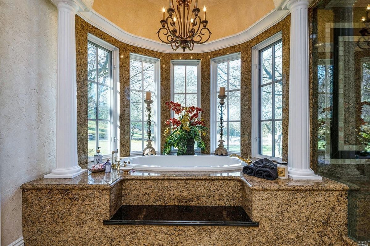 Bathroom with a tub and a chandelier.