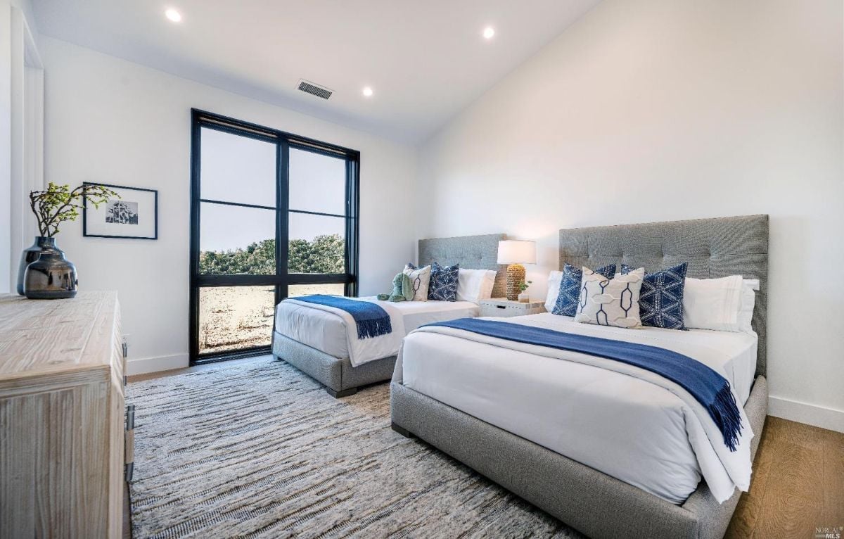 Bedroom with two beds and sliding glass doors.