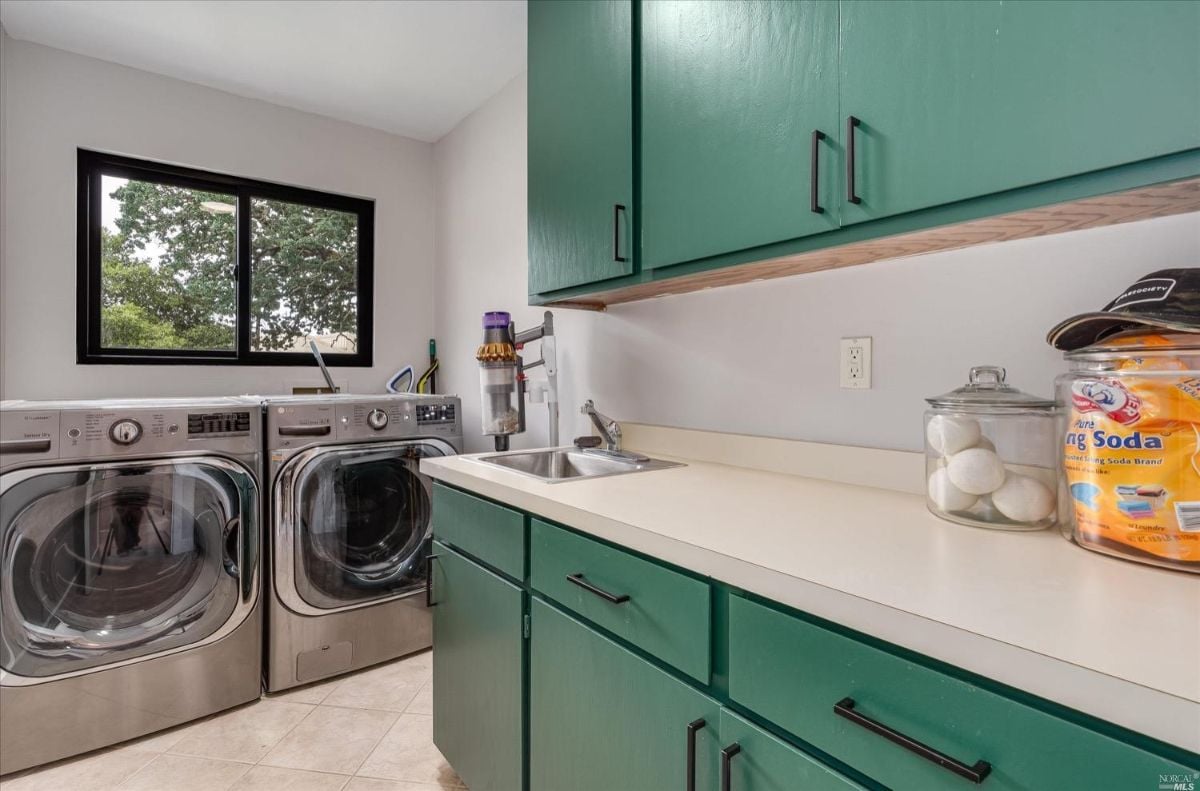 Laundry room with green cabinets and drawers.