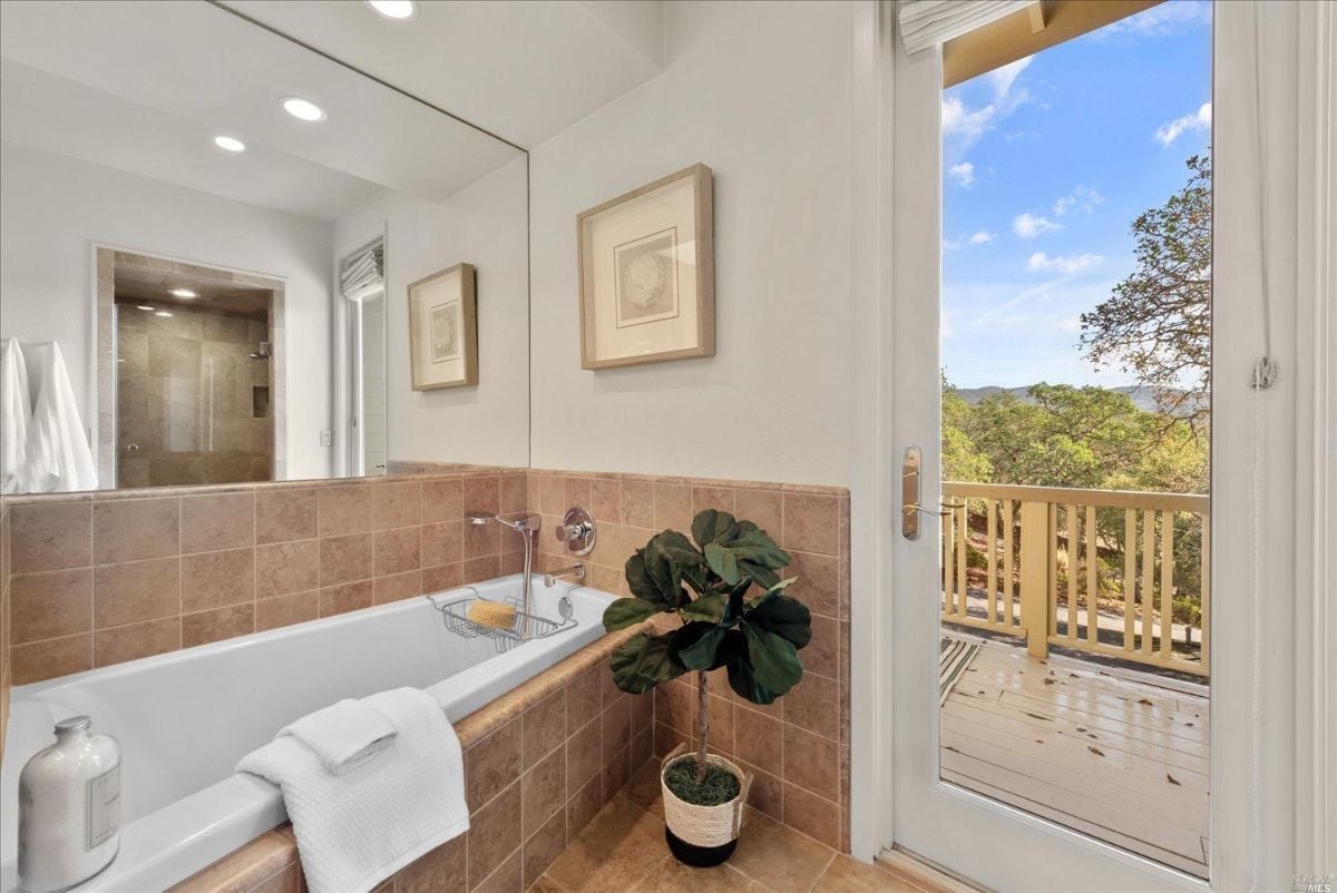 Bathroom with a bath tub and large mirror.