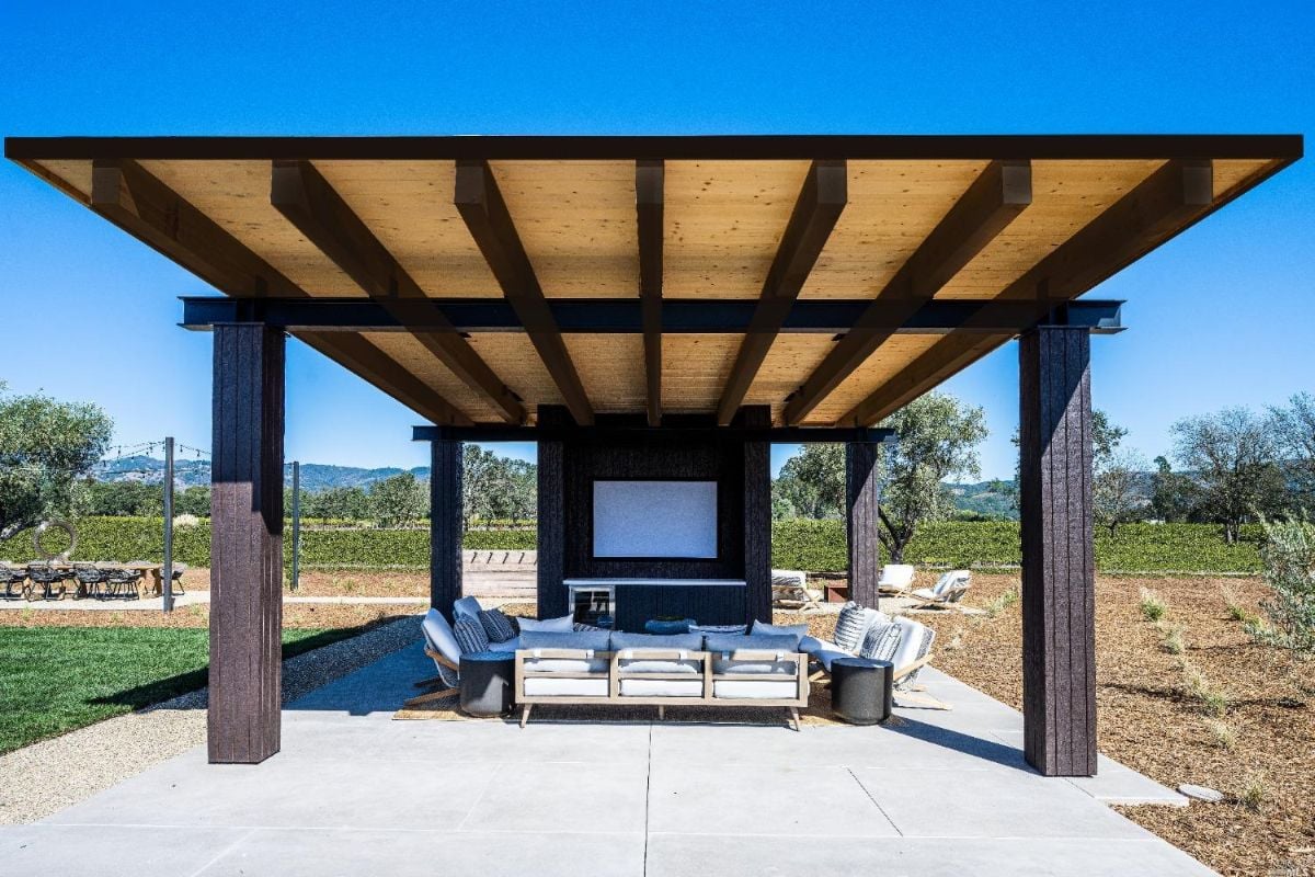 Covered patio with a couch and a television.