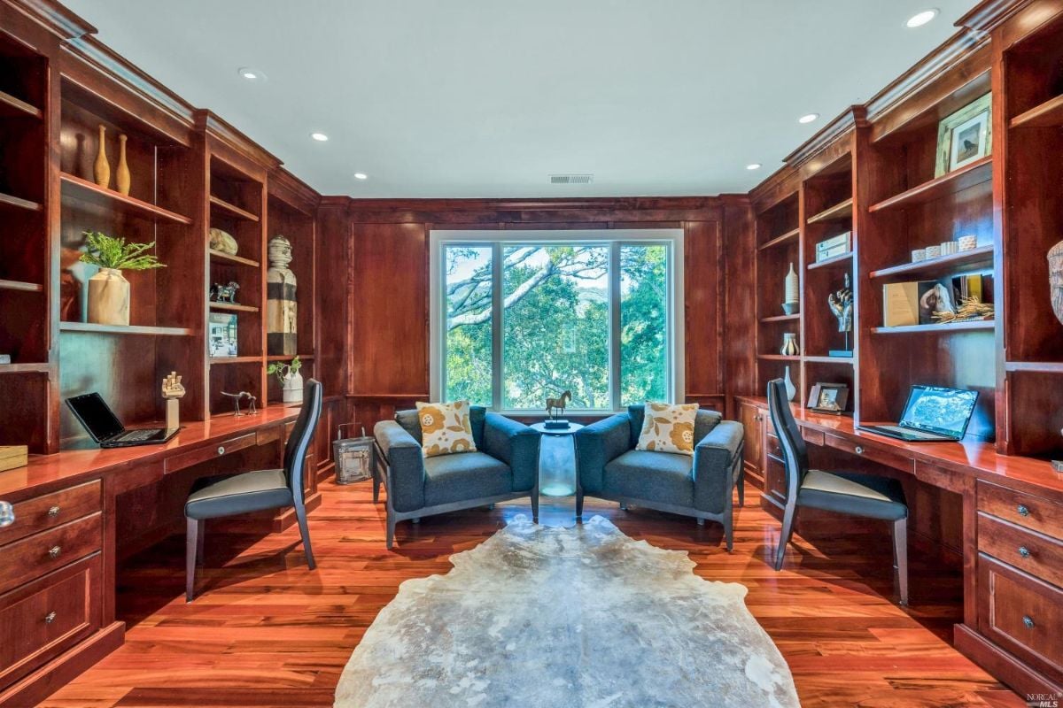 Home office with wooden floors and shelves.