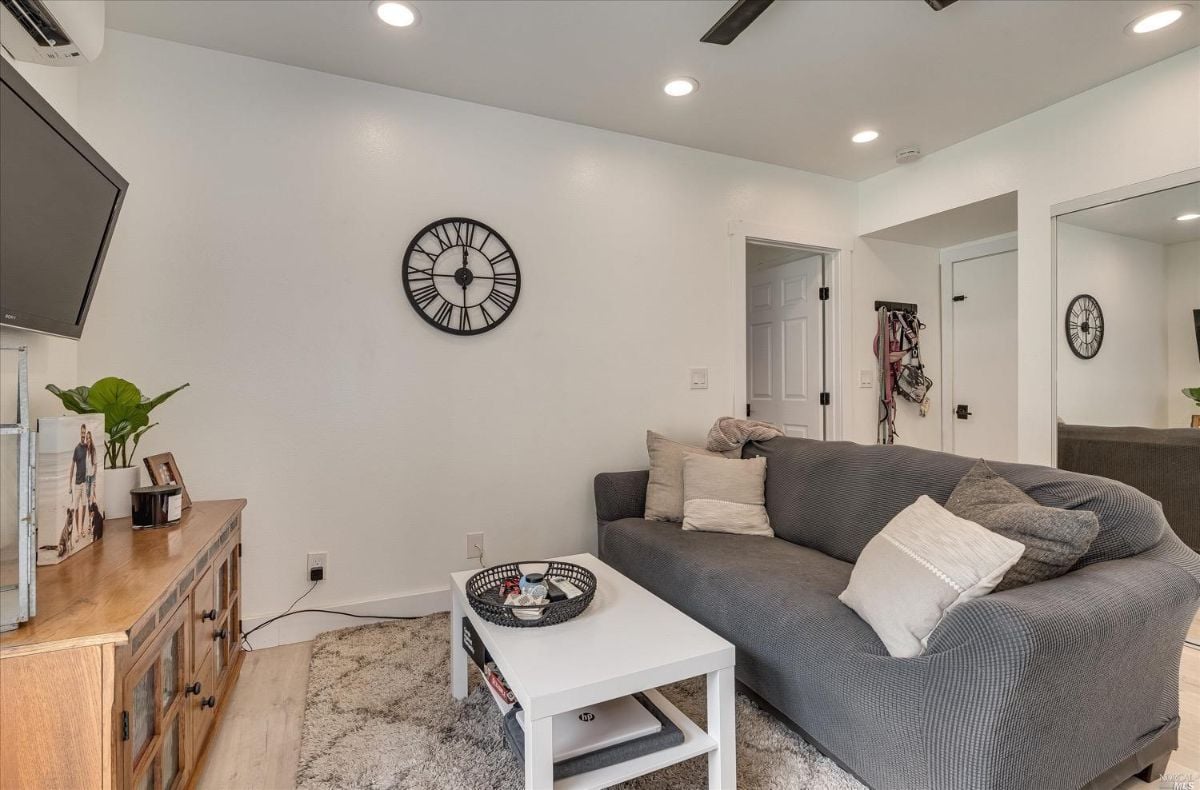 Media room with table, couch, and a huge flat screen TV.