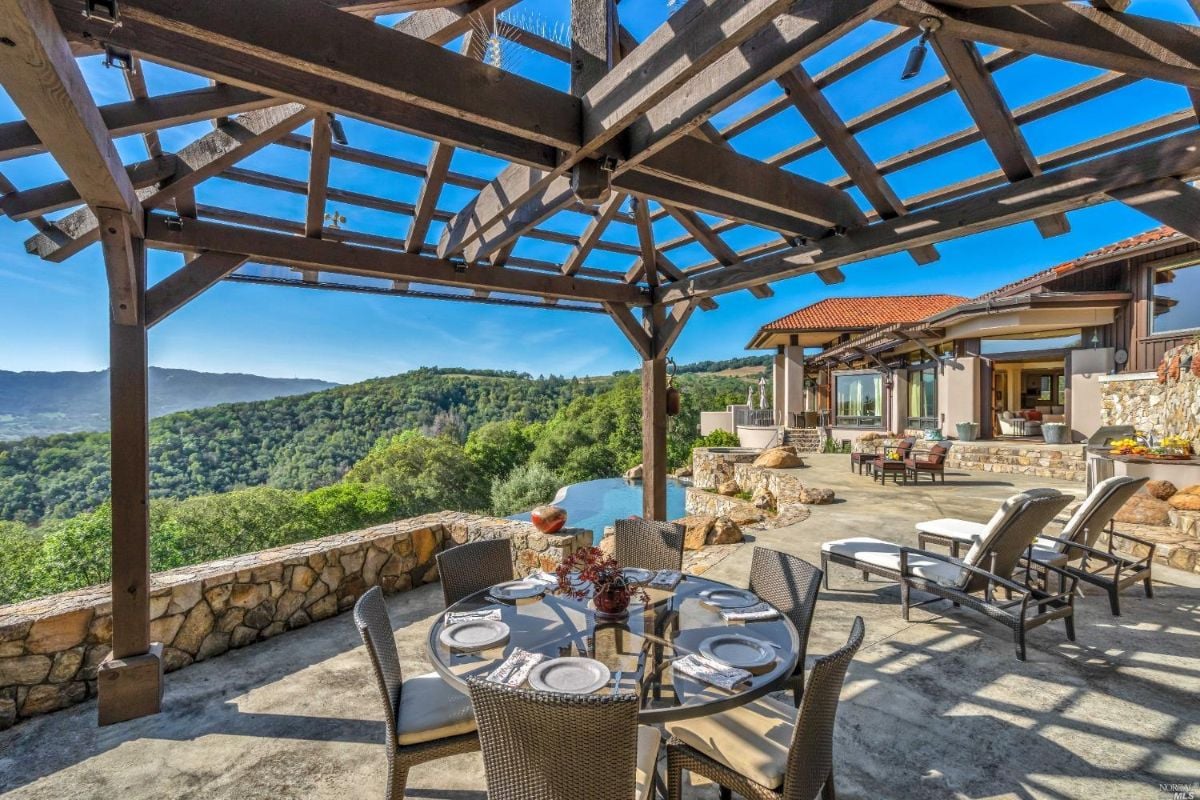 Patio with a table and chairs overlooking the mountains.