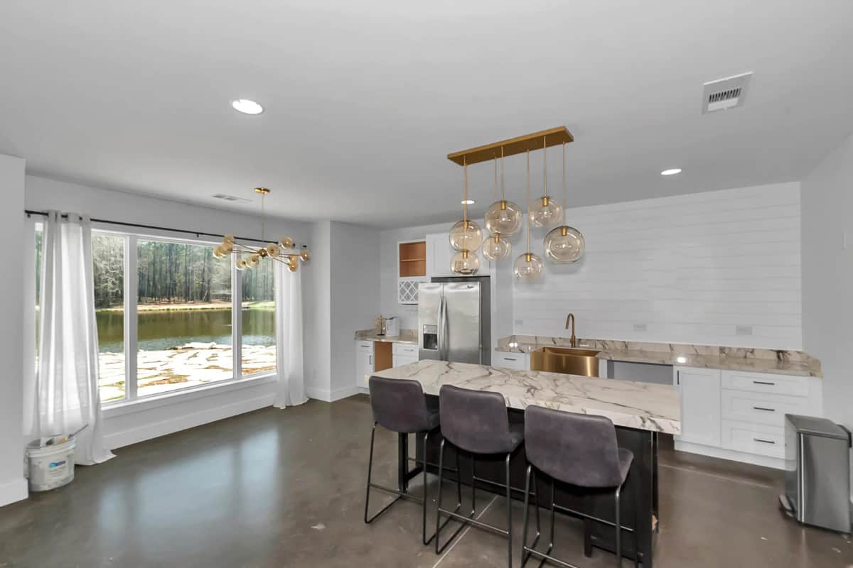 The lower level kitchen has marble countertops, a breakfast island, and an impressive lake view.